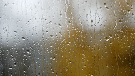 raindrops trickle down a glass window on a gloomy day capturing a calm and melancholic mood