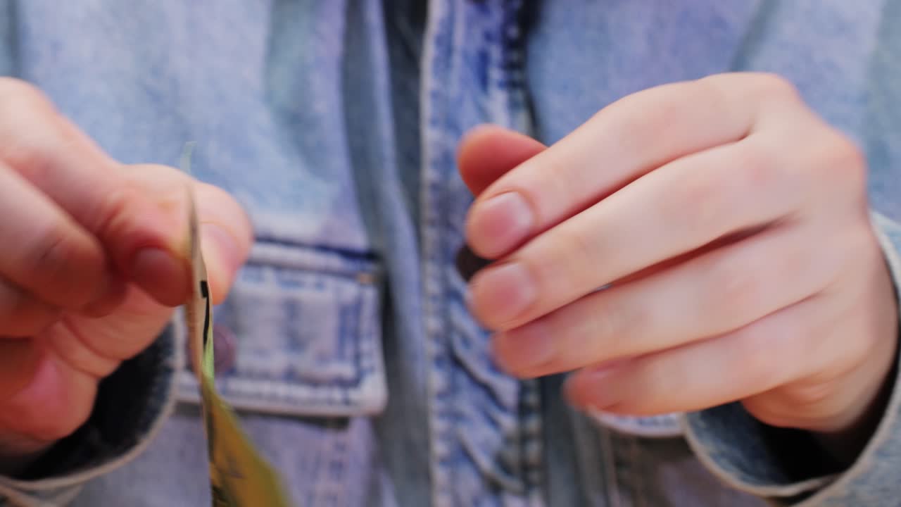 A closeup detail of an individual holding a 100 Euro banknote, showcasing its vibrant and detailed design