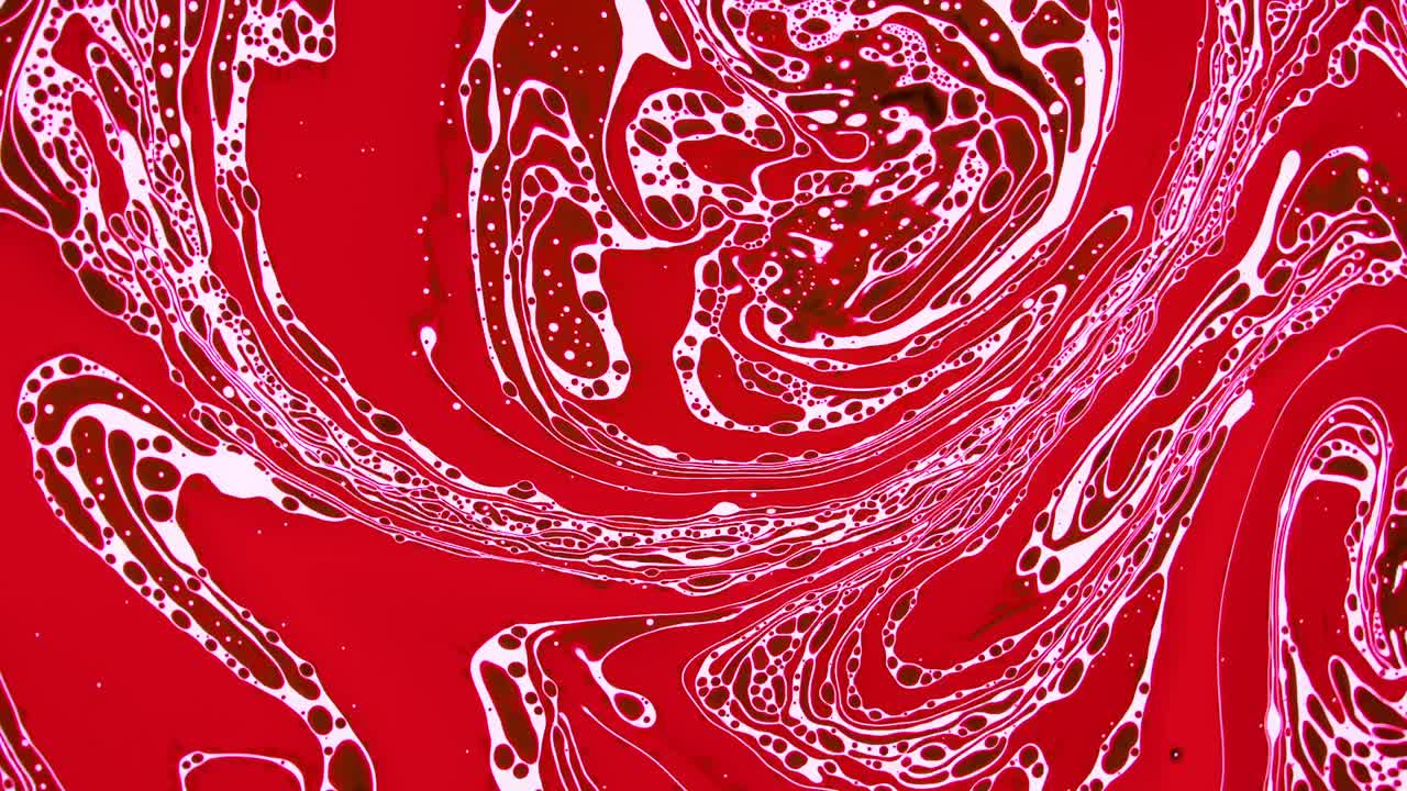 Bold red liquid imagery swirls and tangles together enchantingly