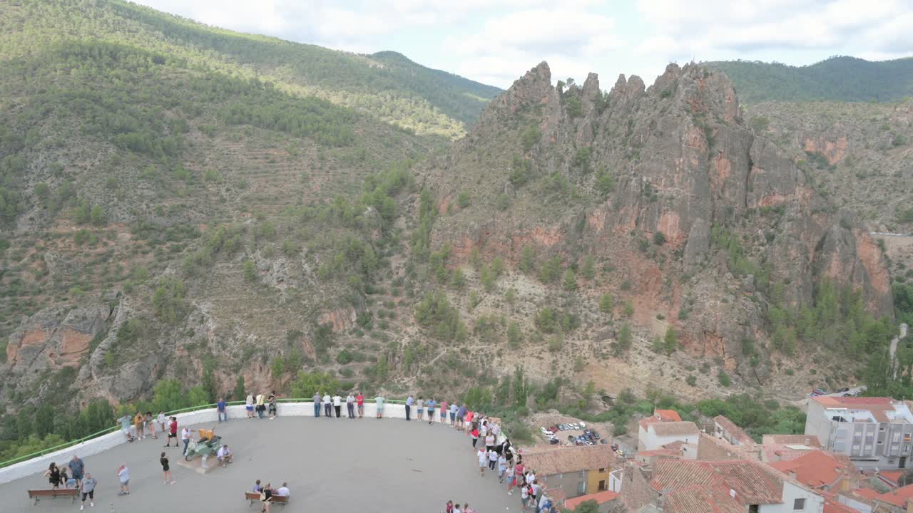 Tourists at the Mirador del Sidecar in Ayna, Albacete, with the mountainous landscape of Los Picarzos in the background