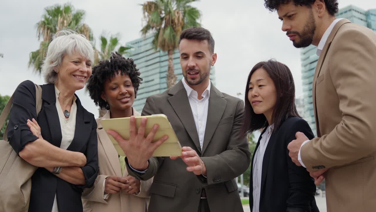 Business team discussing work on a tablet outdoors