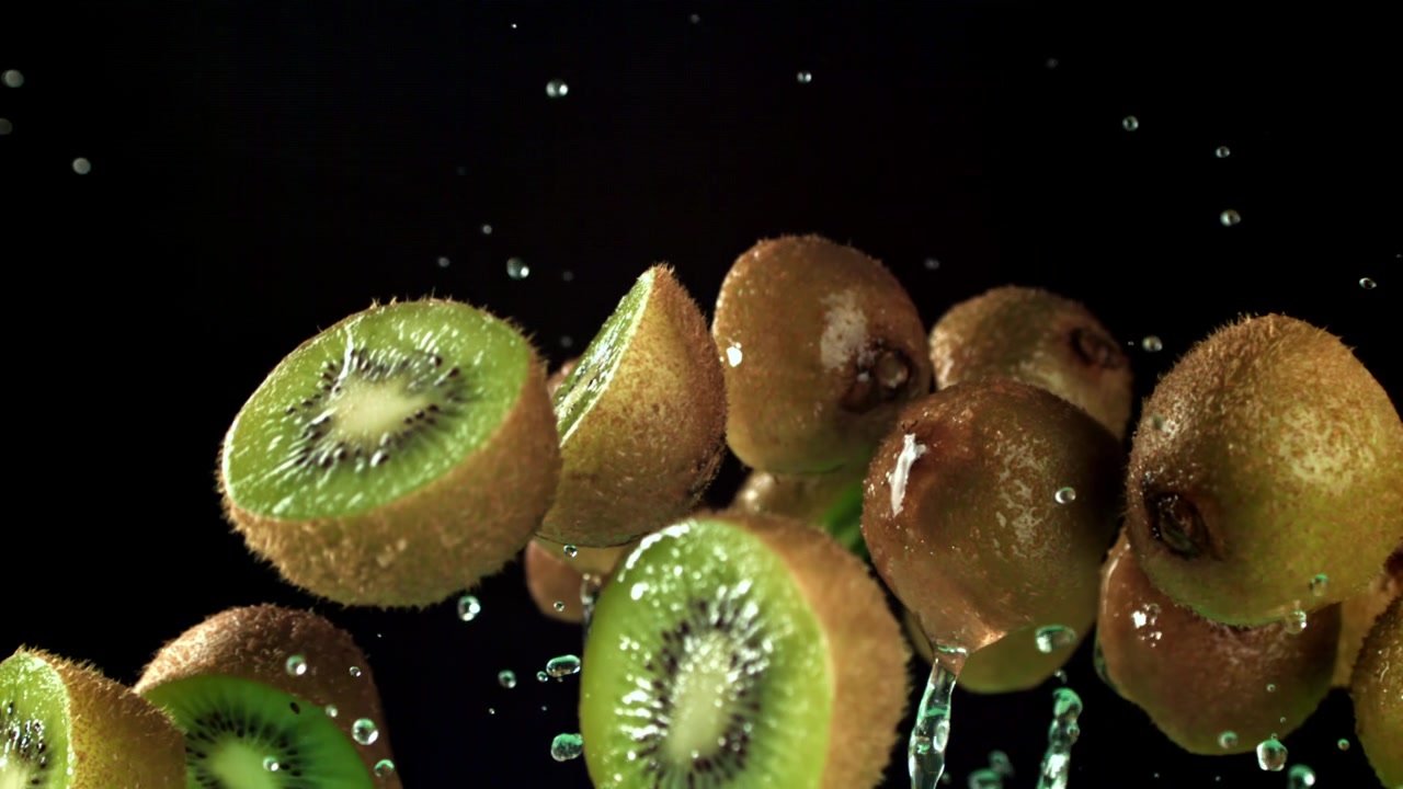 Kiwis frescos y agua salpicando en cámara lenta
