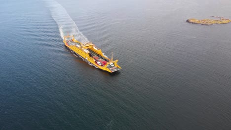 backwards aerial drone flight with view of car ferry in northern gothenburg's territory, sweden