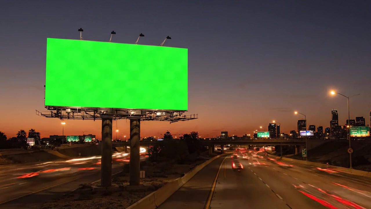 Et grønt billboard oplyser motorvejen, der fanger trafikbevægelser under solnedgang og om natten, og viser en alsidig reklameplads i bymiljøer