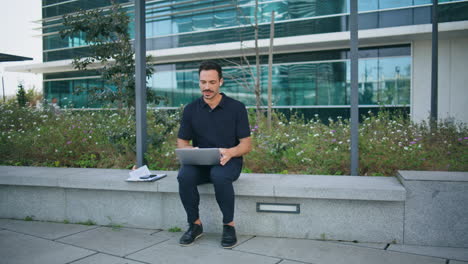 manager talking earbuds working street. man looking computer screen