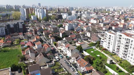 drone shot of a suburban residential area with houses, vegetation, and buildings, sunny day with cars parked on the street - france