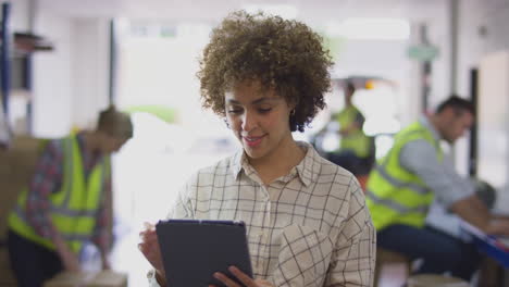 Portrait-Of-Female-Manager-In-Logistics-Distribution-Warehouse-Using-Digital-Tablet