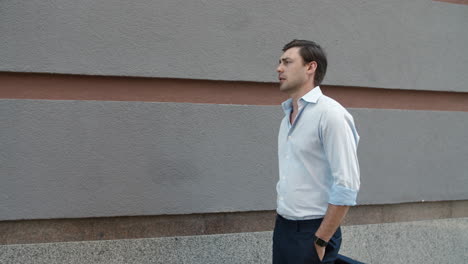 Closeup-businessman-walking-near-building.-Businessman-stretching-neck-outdoor