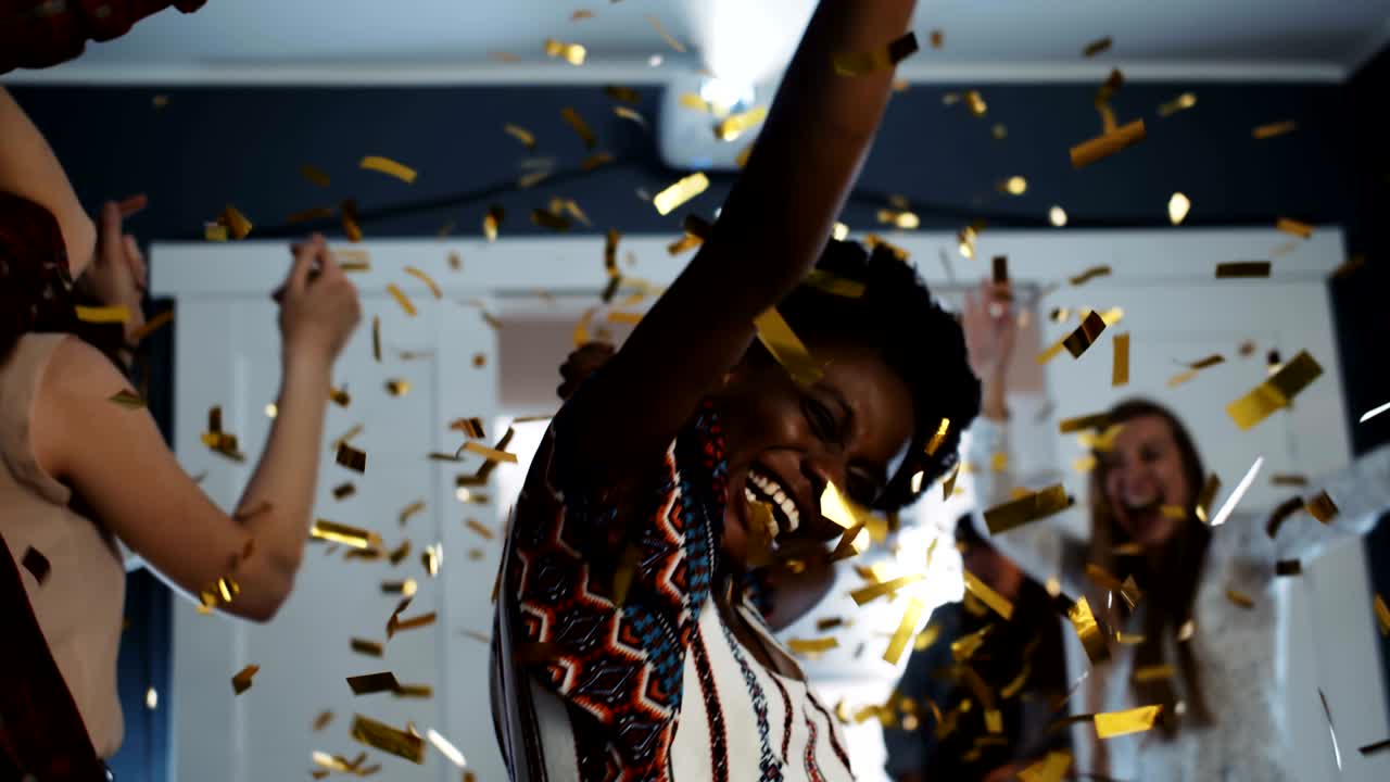 Happy young African female student having epic fun dancing with college friends at confetti birthday party slow motion.