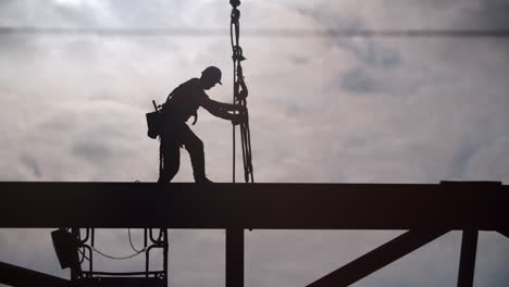 silhouette of construction worker on steel beam