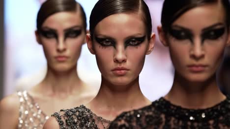 high fashion runway scene featuring models with dramatic eye makeup and captivating expressions showcasing evolving trends in contemporary fashion