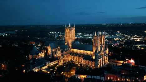 Aerial-drone-video-captures-the-renowned-Lincoln-Cathedral-in-Lincolnshire,-UK,-at-dusk,-showcasing-its-majestic-Gothic-architecture-with-illumination