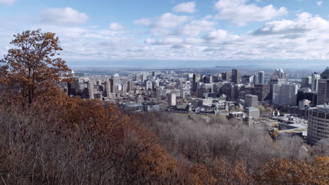 Reveal-of-the-Montreal-skyline-from-the-Mount-Royal-in-autumn,-in-Quebec,-Canada