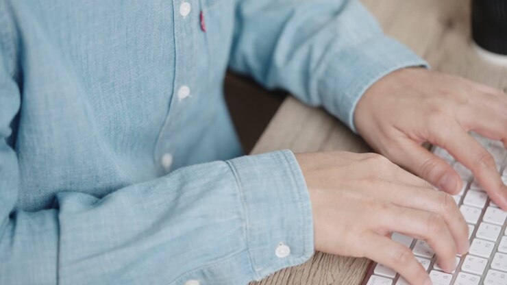 la mano di una donna d'affari che scrive una tastiera su un computer desktop in un ufficio
