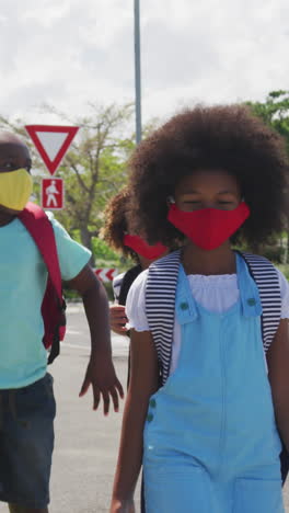 group of kids wearing face masks walking on the road