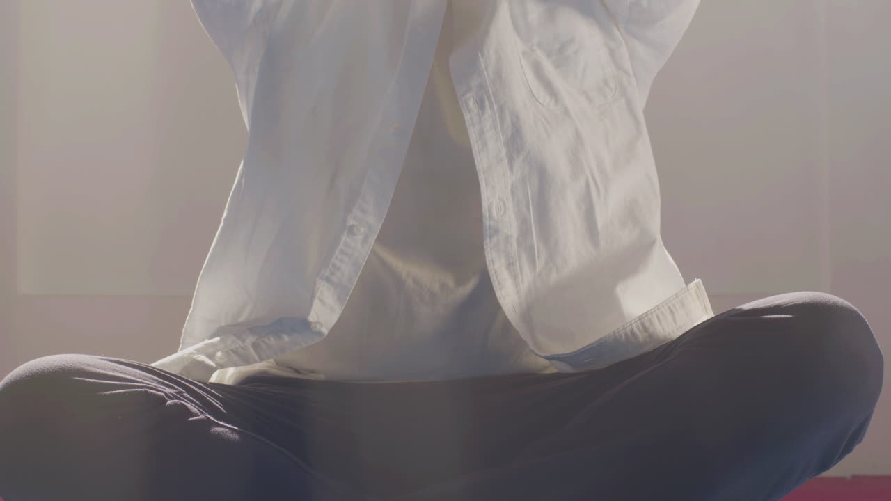 인식할 수 없는 남자가 로터스 자세로 손을 움직인다.