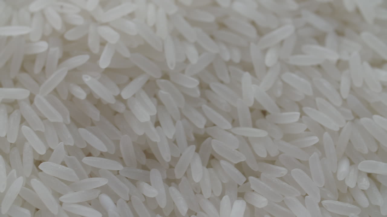 Macro di chicchi di riso bianco che vengono spalati al rallentatore