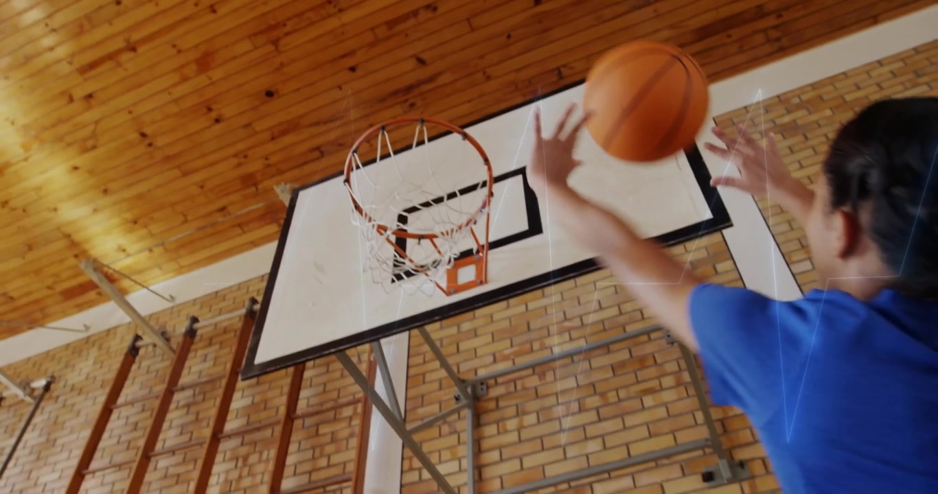 Four girls shooting basketball under hoop inside school gym, showing animated education data chart