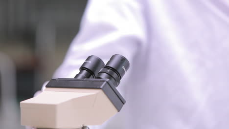 estudiante mirando a través de un microscopio