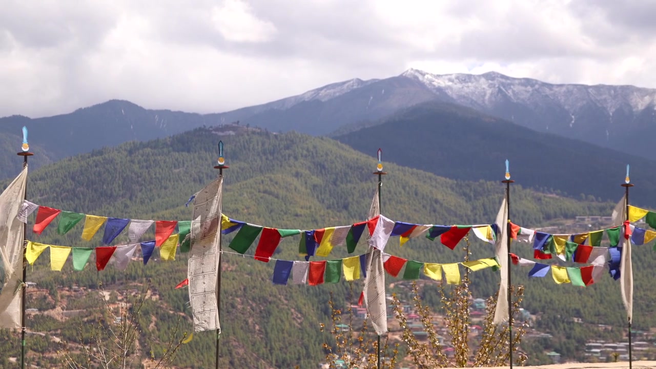 Bhutan Vadisi Üzerindeki Ormanlık Dağların ve Karla Kaplı Zirvelerin Manzarasını Çerçeveleyen Sıra Sıra Dua Bayrakları