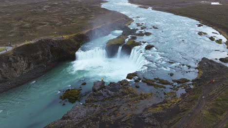 a man standing close to the stunning godafoss waterfall in northern iceland