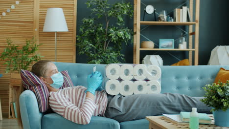 woman relaxing on sofa during pandemic with toilet paper