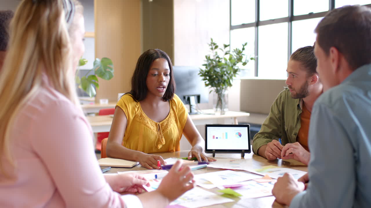 Young African American woman leads a casual business meeting at the office