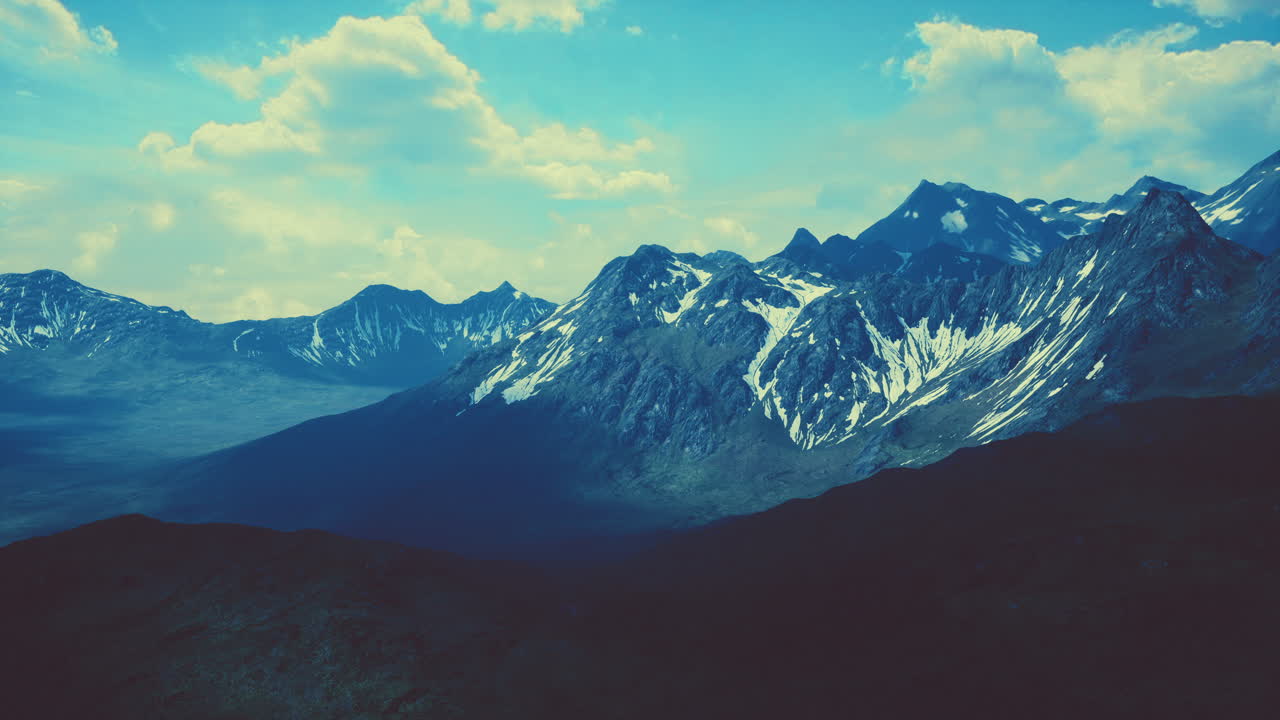 Aerial Over Valley With Snow Capped Mountains In Distance