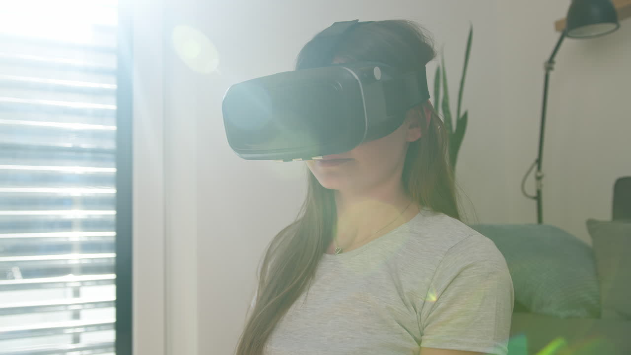 ragazza che si diverte usando un auricolare vr, guardando e catturando oggetti virtuali