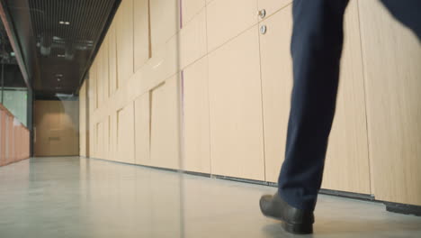 an unrecognizable businessman walks backwards with a trolley 1