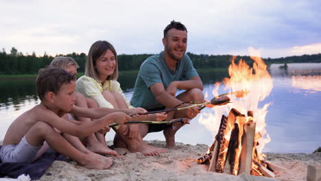 family eating sausages on the beach