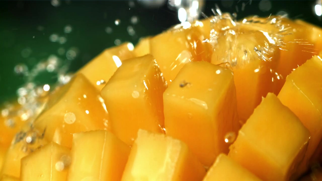 Rinfrescanti gocce d'acqua che schizzano su cubetti di mango maturo