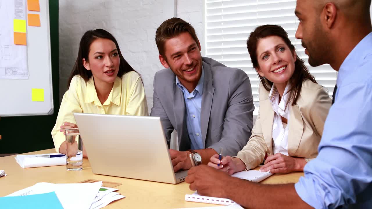 equipe de negócios casual tendo uma reunião usando laptop