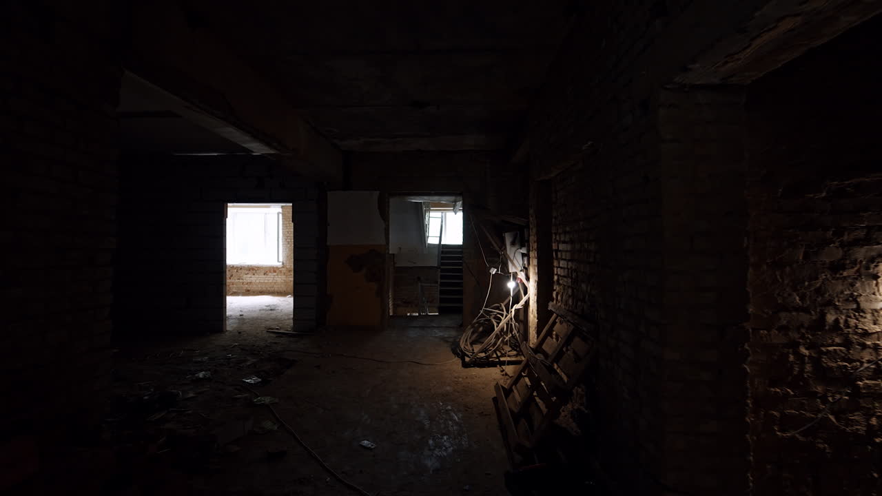 Dark empty premises of the building under construction. Old shabby house with multiple rooms.