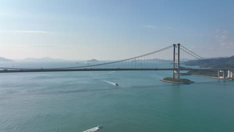 traffic drives over the tsing ma suspension bridge on a clear day