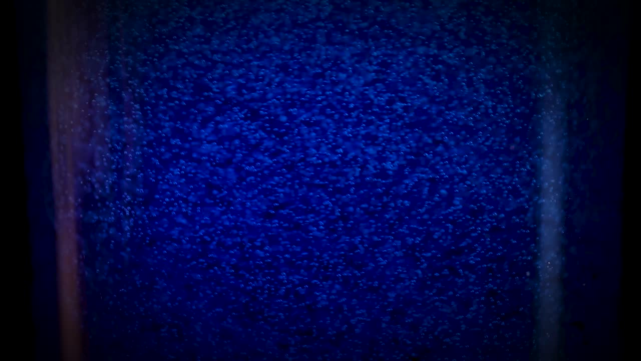 파란색 탄산 음료에서 거품이 상승하고 있습니다.