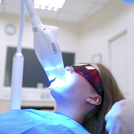 woman patient is treating her teeth at dentist's. modern technology at dentistry. stomatologist using new equipment while caring of patient's teeth.