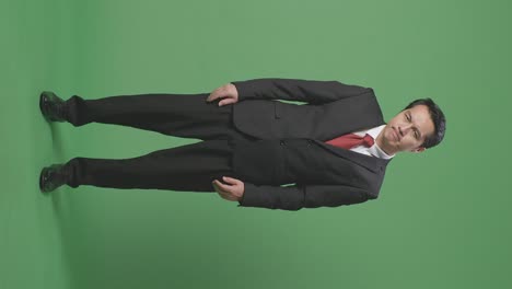 cuerpo lleno de hombre de negocios asiático no está satisfecho y sacude la cabeza mientras está de pie frente a la pantalla verde