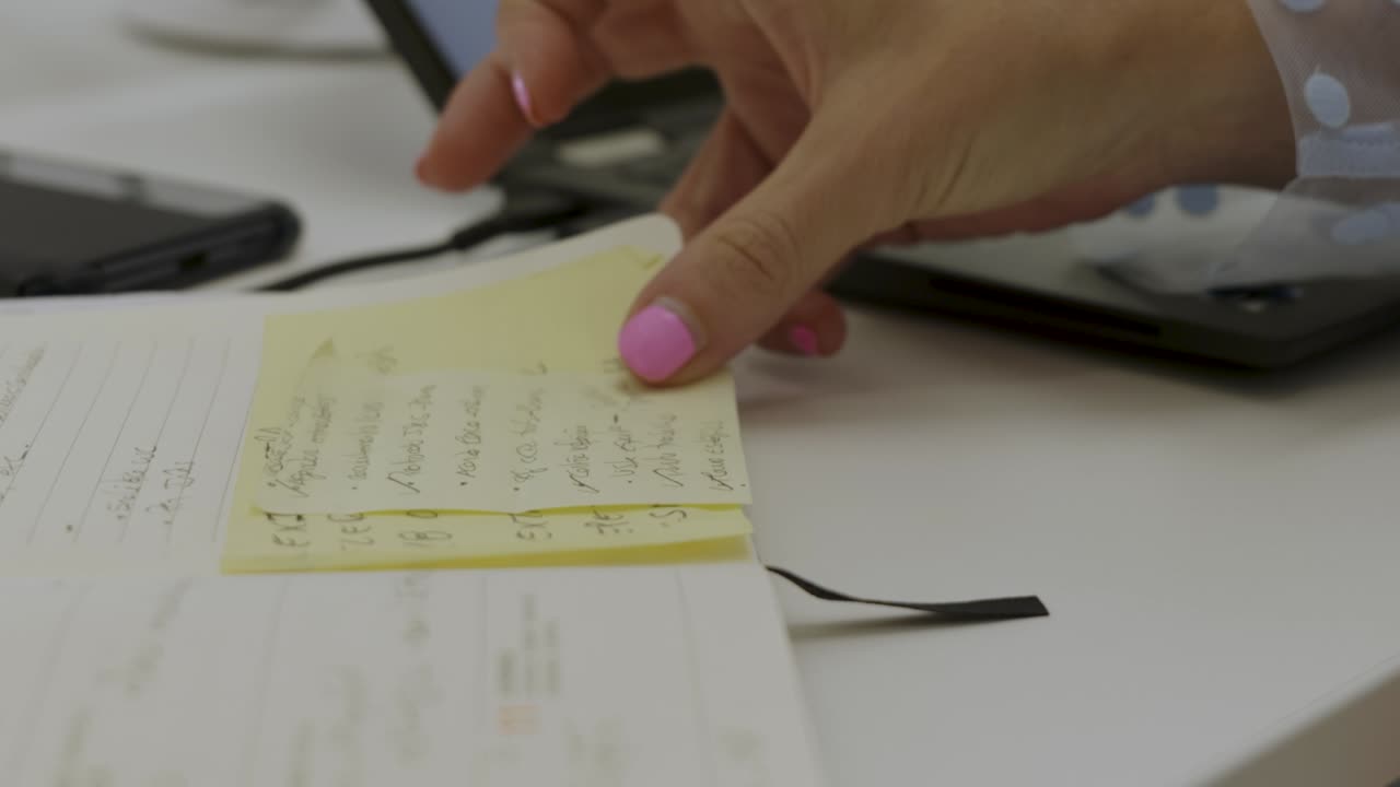 Woman&acute;s hand checking postits while working on the computer