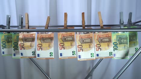 money hanging to dry with clothespin - euro money banknotes after  washing machine - illegal cash 50, 100 €  and mafia money laundering - increase in the cost of living, energy and gas