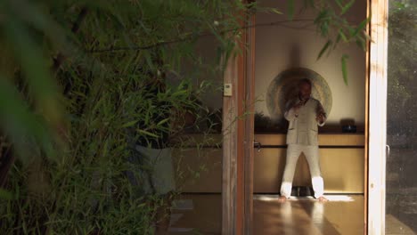 man performing chi kung exercise in spacious room