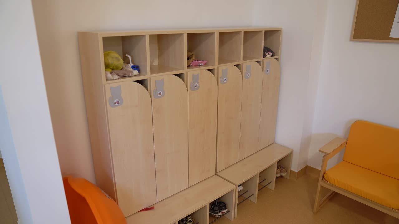 Armadietti e scomparti in legno vuoti in uno spogliatoio di scuola materna.