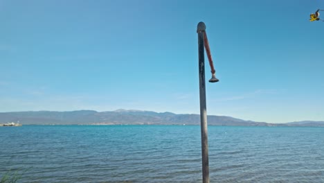 old outdoor beach shower head sprinkler on mediterranean seaside