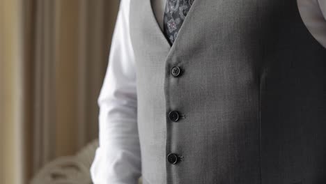 buttoning jacket with hands close up, man in suit fastens buttons on his jacket preparing to go out