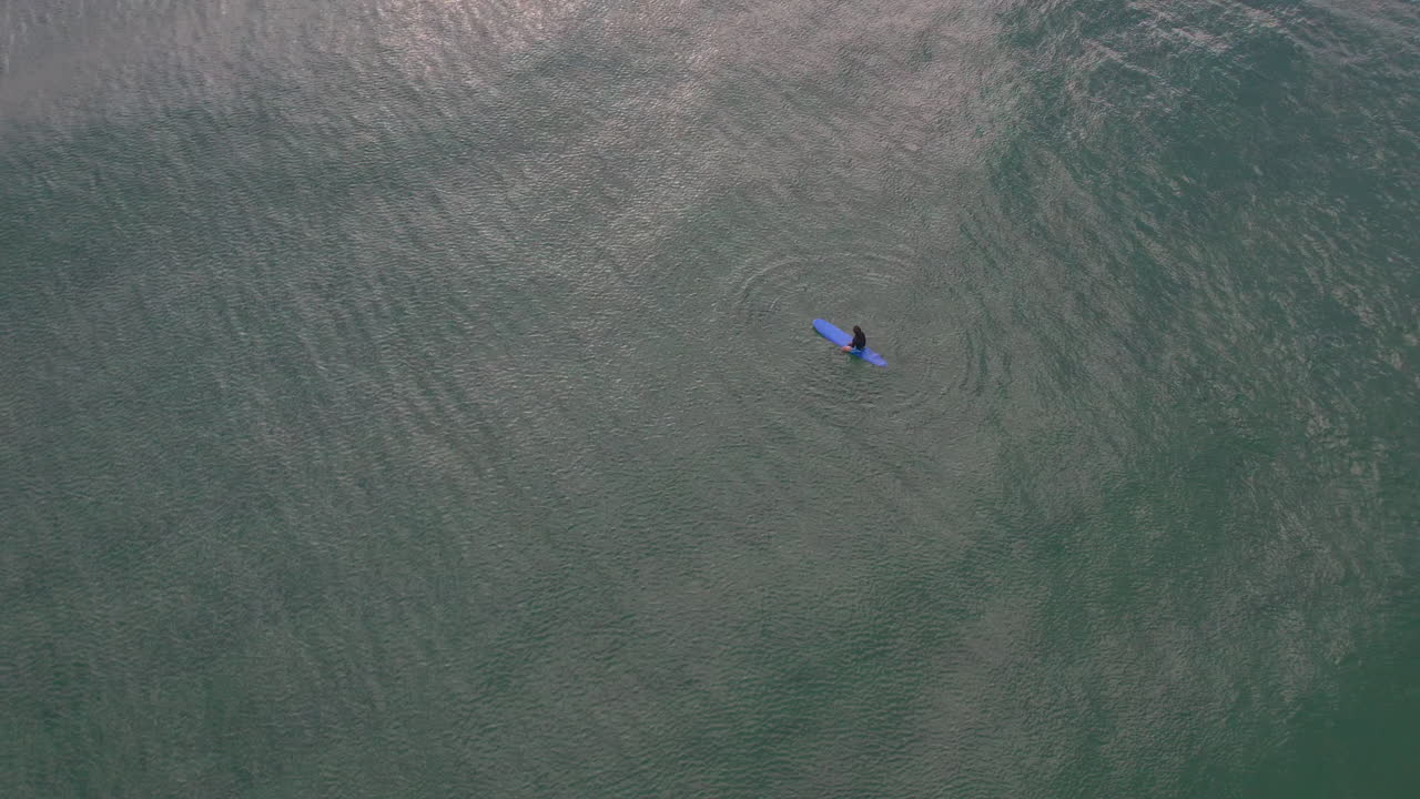 인어 비치 골드 코스트 qld 호주에서 완벽한 파도를 기다리는 동안 일출을 감상하는 잔잔한 아침 바다에 앉아 서퍼 위의 공중보기