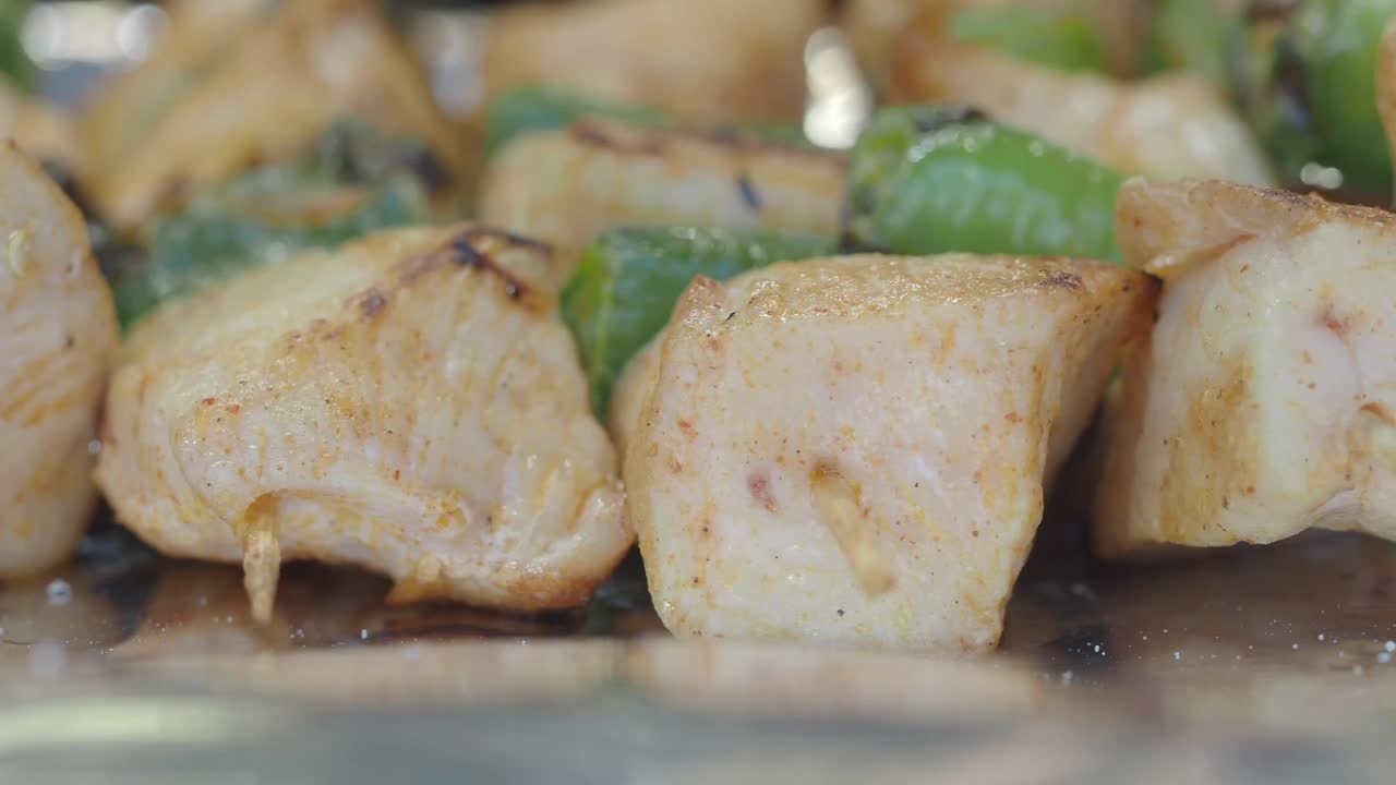 Primo piano di spiedini di pollo e peperoni in cottura sulla griglia