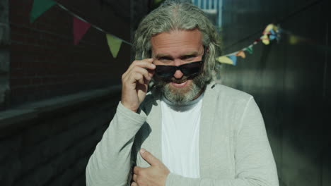 smiling man with sunglasses in urban alleyway