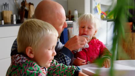 father wiping his daughters mouth with napkin cloth at home 4k