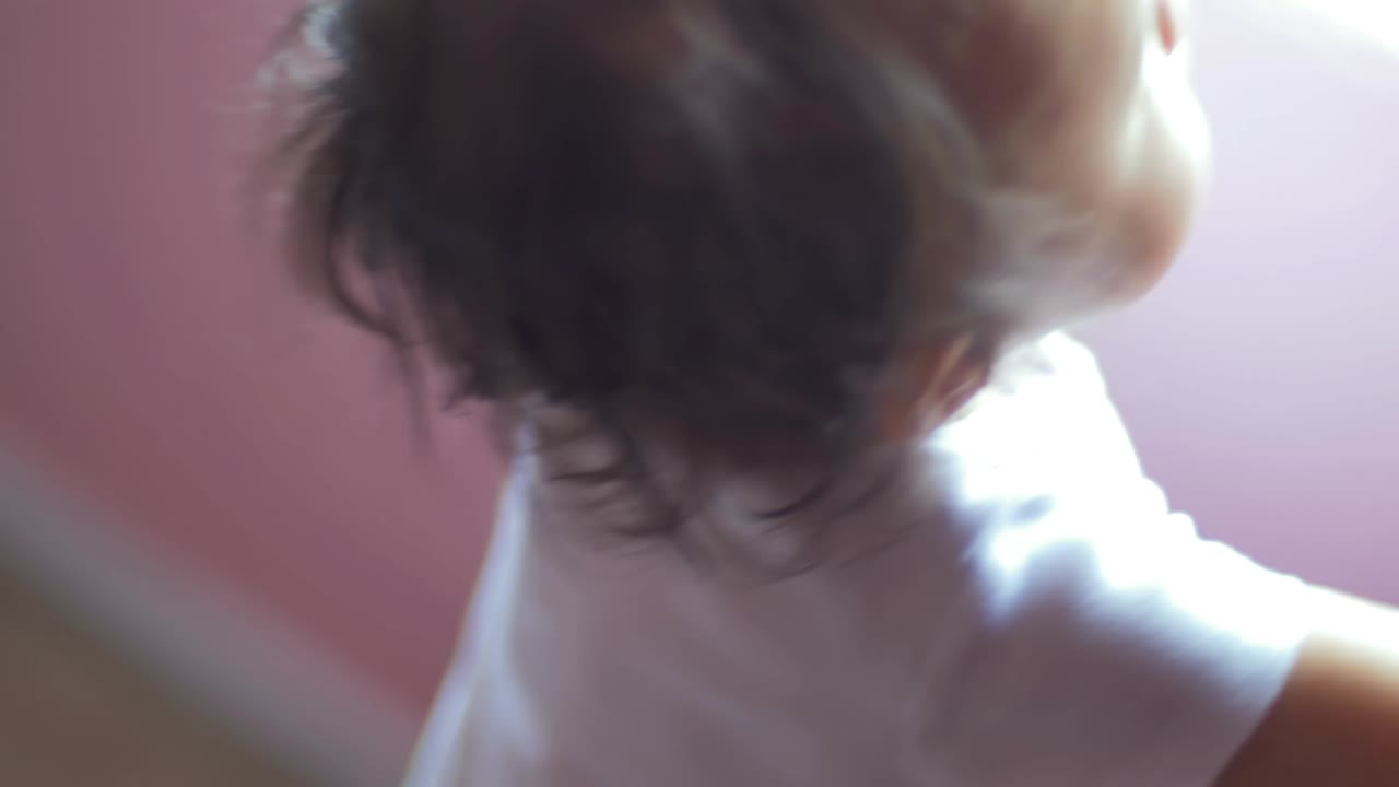 유아가 방 창문 밖을 바라보며 드폰 버튼을 러