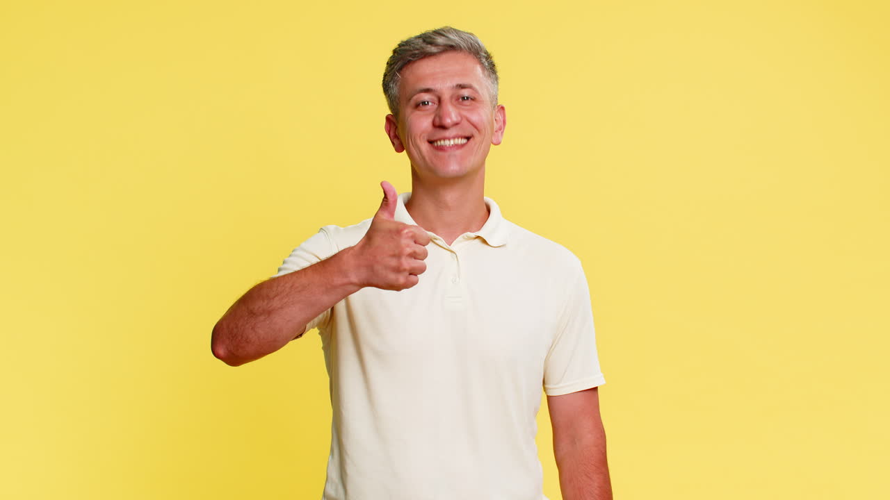Man smiling confidently showing thumbs up approval gesture with hand to express trust and support